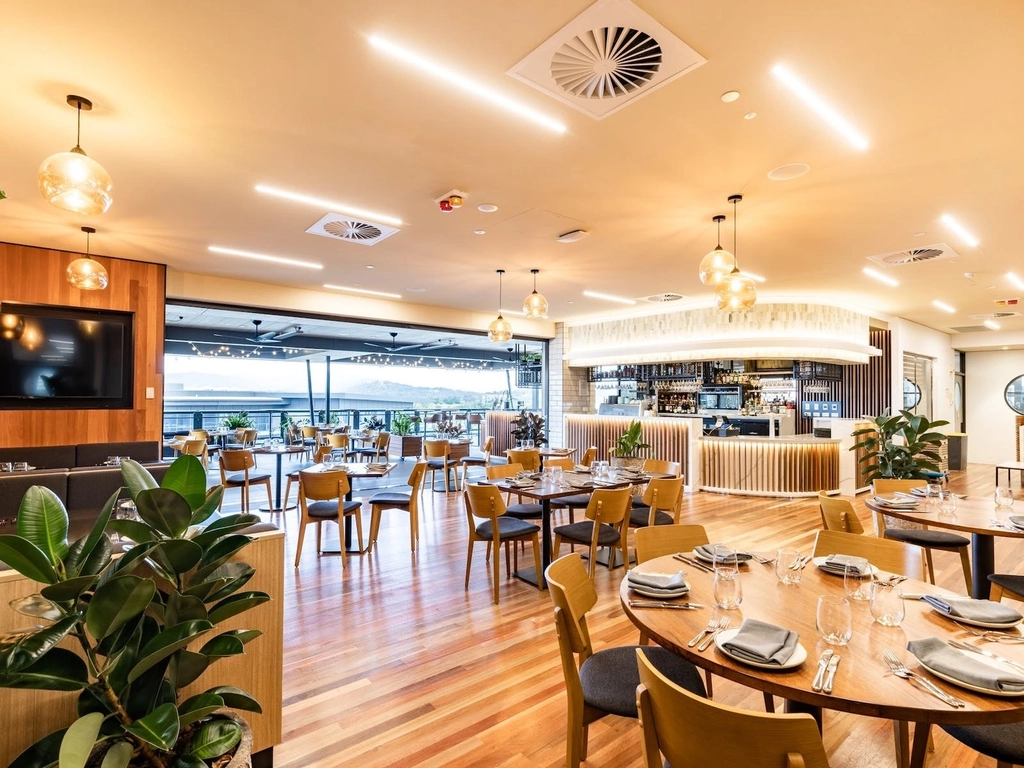 Warm wood tones, indoor and outdoor seating, beautiful lighting, welcoming space