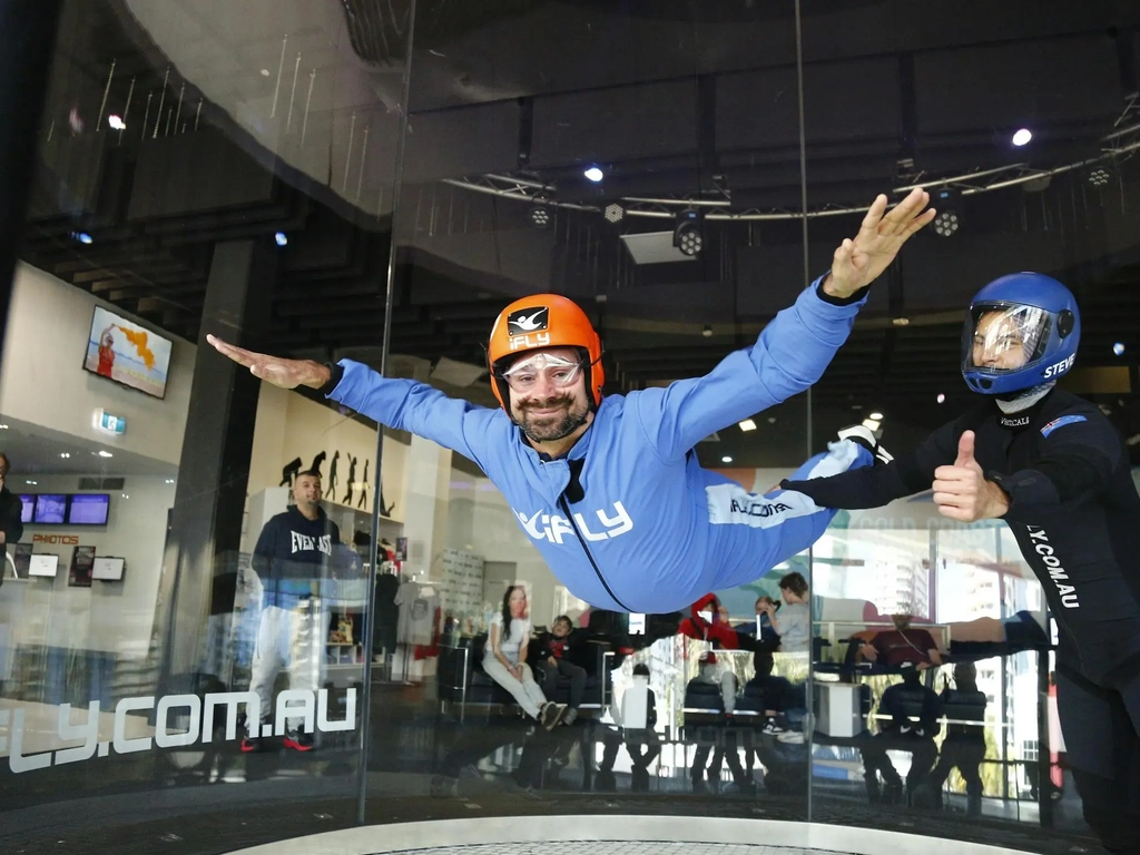 Male with a beard flies solo with arms outstretched