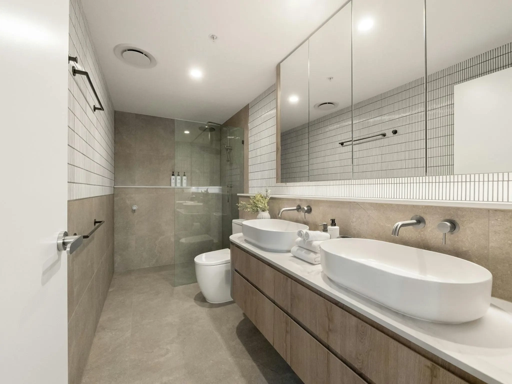 Ensuite bathroom with twin basins, stone floor and walk-in shower