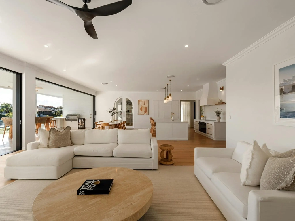 Open plan living room with sliding doors opening to a covered alfresco and lawn