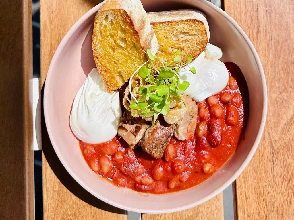 Confit pork belly, puffed skin, spiced beans, poached eggs, and rustic