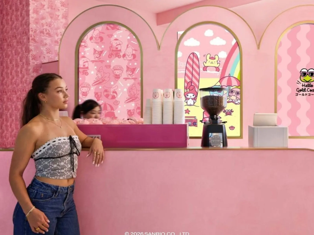 A cafe area with pink seating and a wall featuring colorful Sanrio character art.
