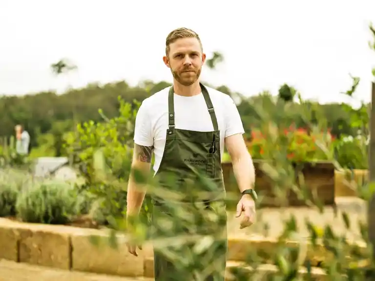 The Paddock Executive Chef Simon Furley walking through Hazelwood's lush green kitchen garden