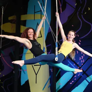 Adults and Teens Aerial Classes and Workshops - Pictured is a lady and teen girl sitting on Trapeze.