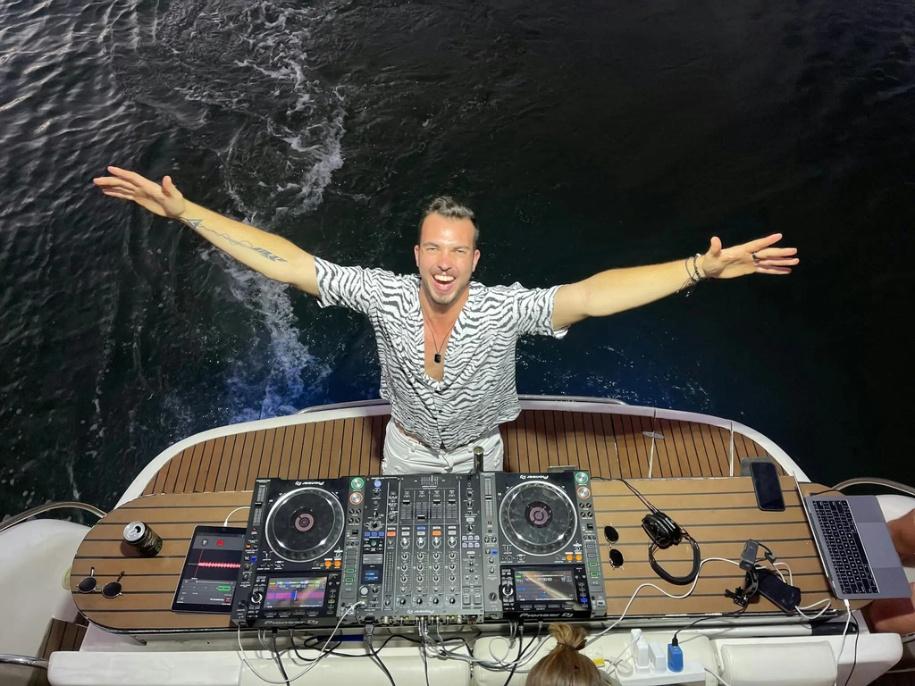 DJ playing music on the rear deck of a luxury yacht during a celebration on the Gold Coast.