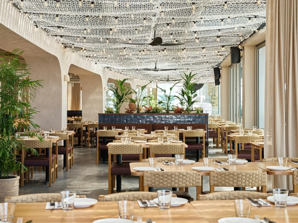 Rows of beautiful tables and chairs with wood crafted finishes in Hurricane's Surfers Paradise.