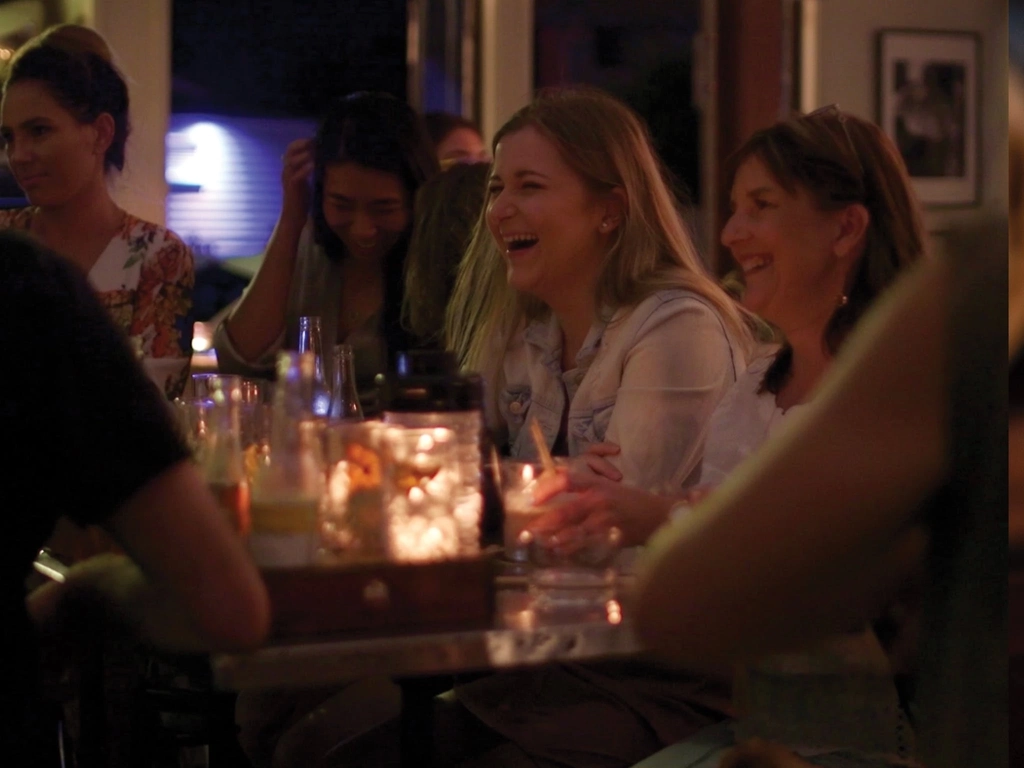 Guests enjoying an evening at the distillery, laughing at a table.