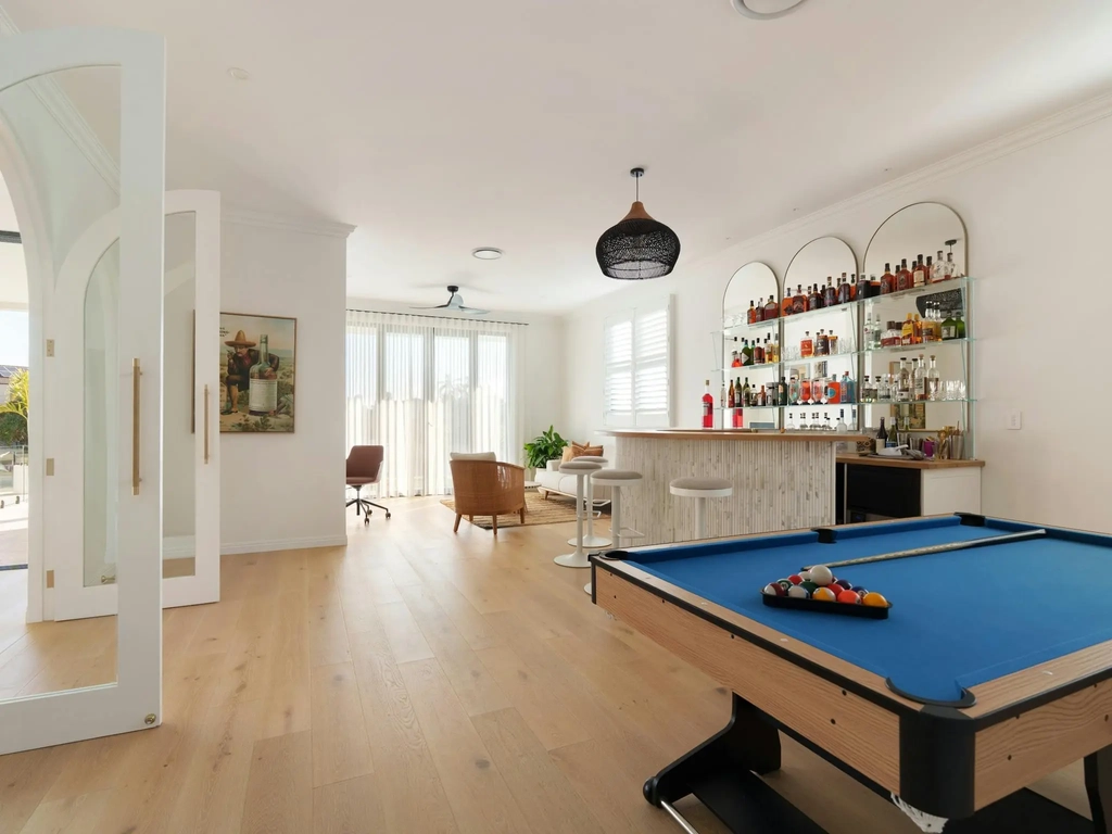 Bar room with a curved marble bar, stocked shelving and a pool table