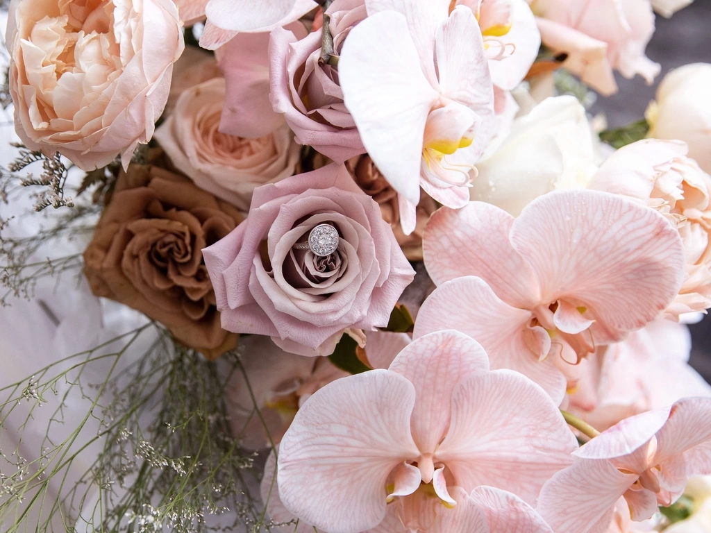 A bridal bouquet of roses and phaleanopsis orchids.  In varying pink, nude and coffee tones.