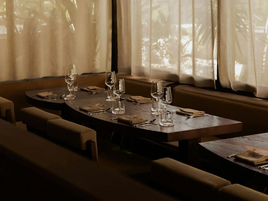 Table inside set with wine glasses with light streaming in through the windows