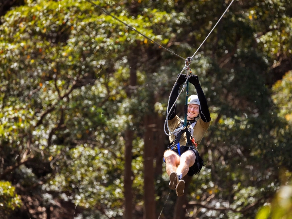 Man smiling doing a zipline