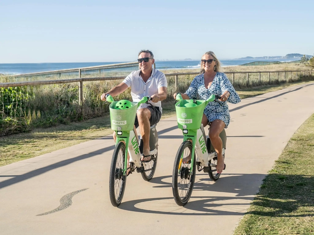 Couple riding bike along the oceanway