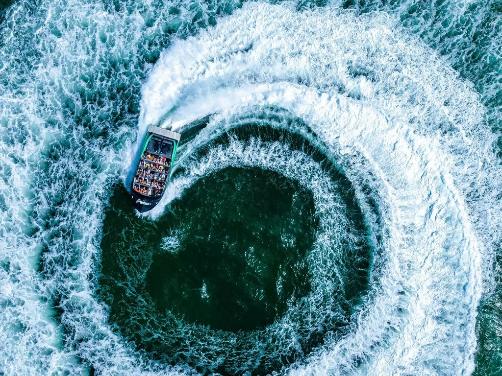 Aerial view of Arro Jet Boat doing a spin with white wash everywhere.