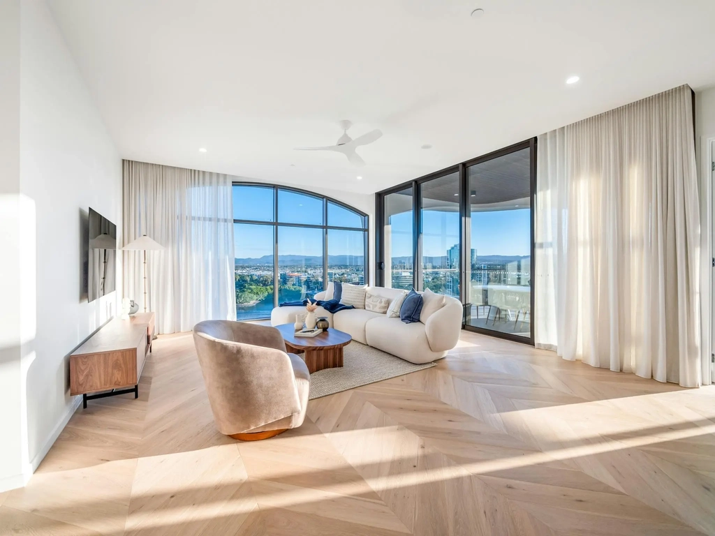 Second lounge set behind a tall arched window with river and hinterland views