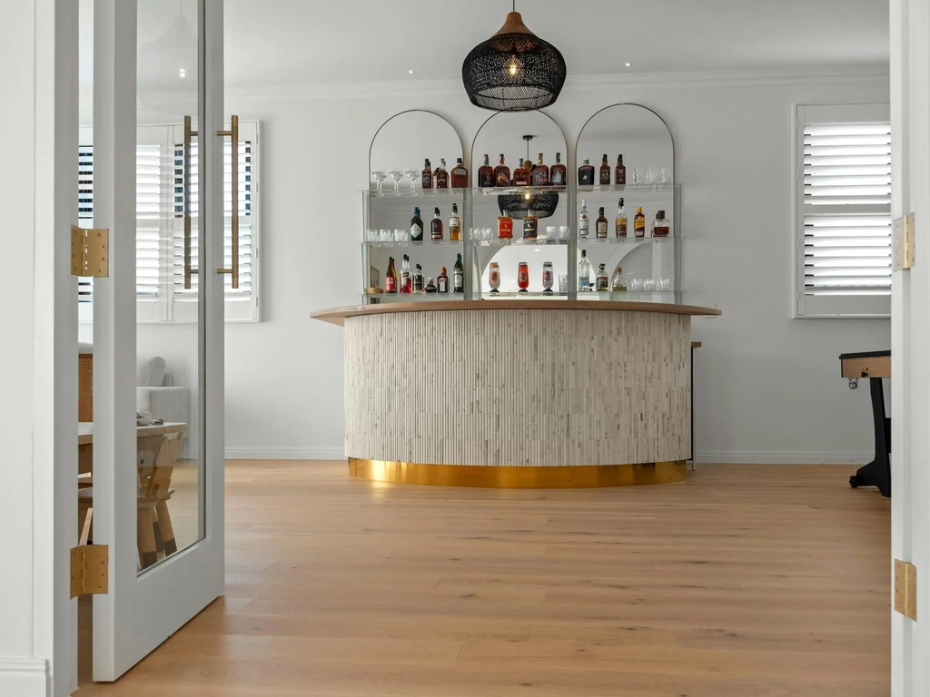 Curved bar with fluted marble front behind a glass door