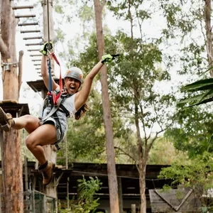 Woman ecstatic as she flies across a zipline.