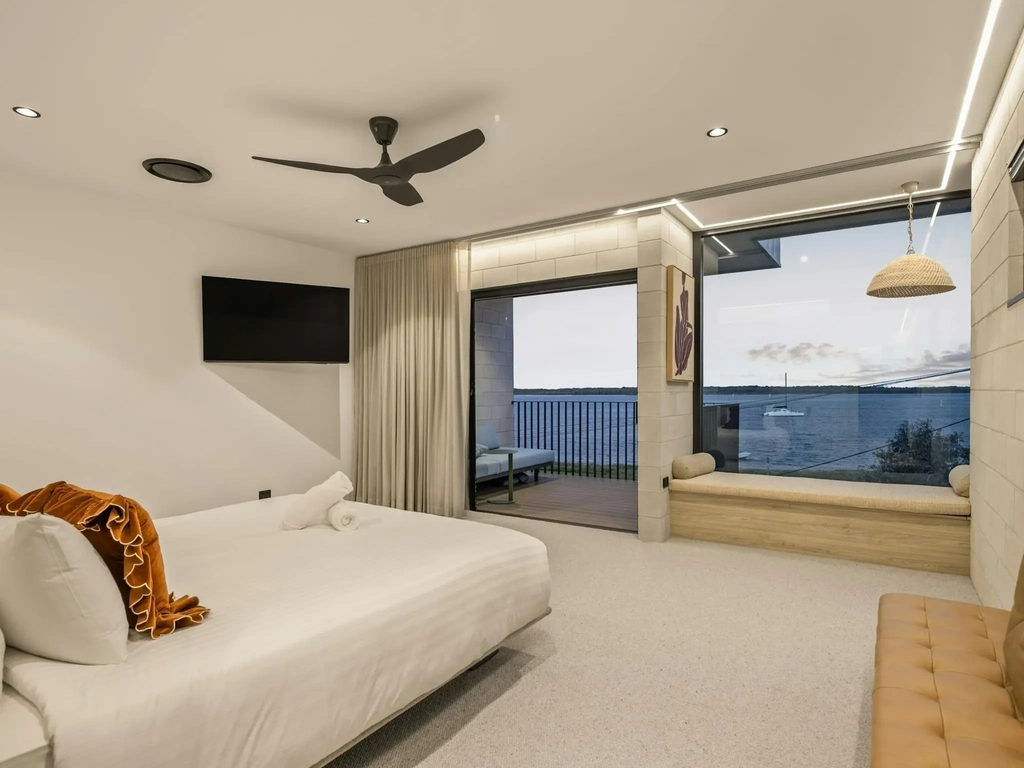 Main bedroom with a wall of glass looking over the water