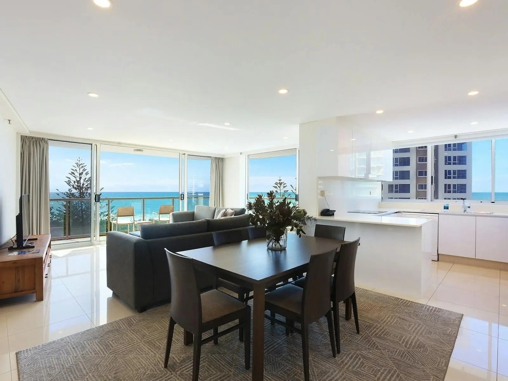 Open plan living with dining room, kitchen and lounge room flowing into the balcony with ocean views