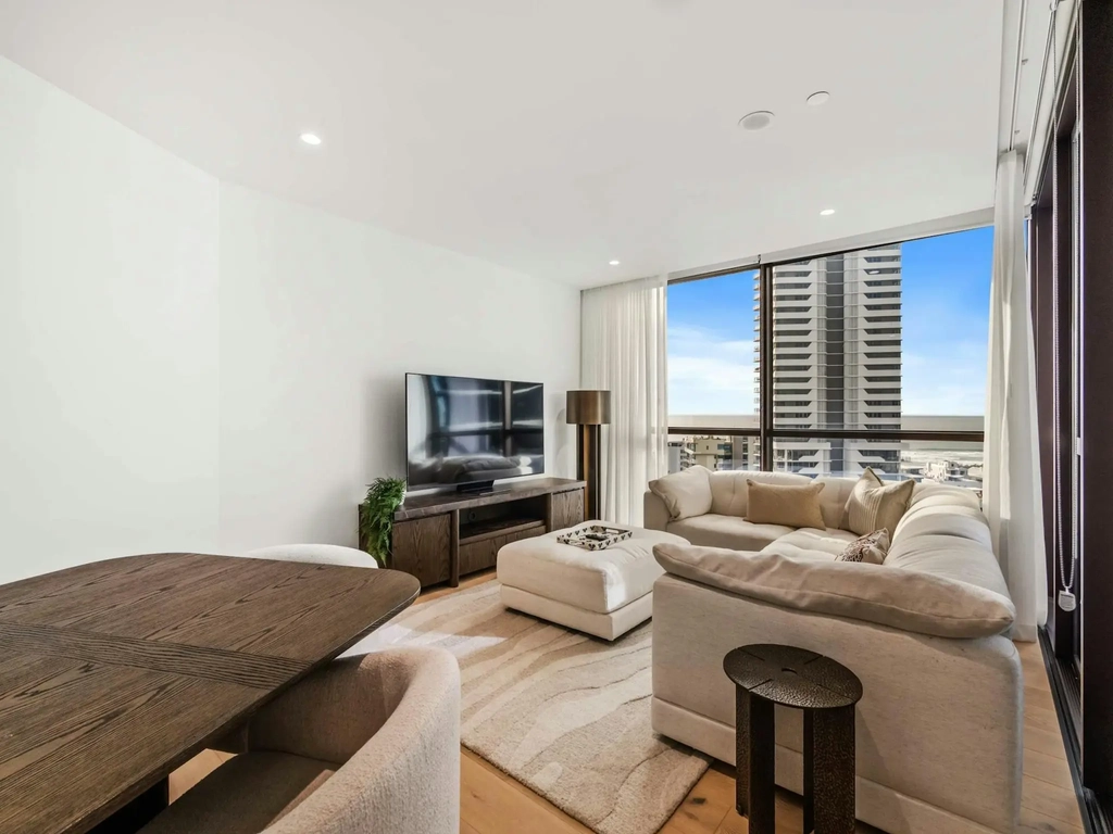 Family apartment living room with a large sofa and ocean-facing windows at Mermaid Beach