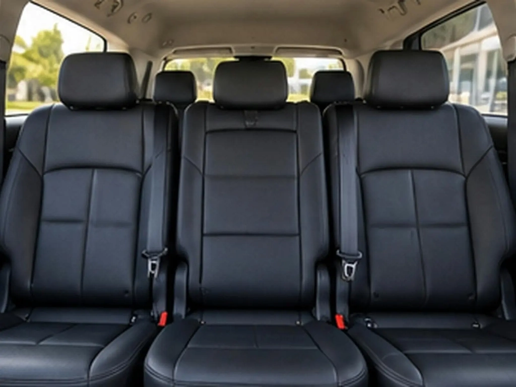 Spacious passenger seating inside a Kia Carnival used for private airport transfers.