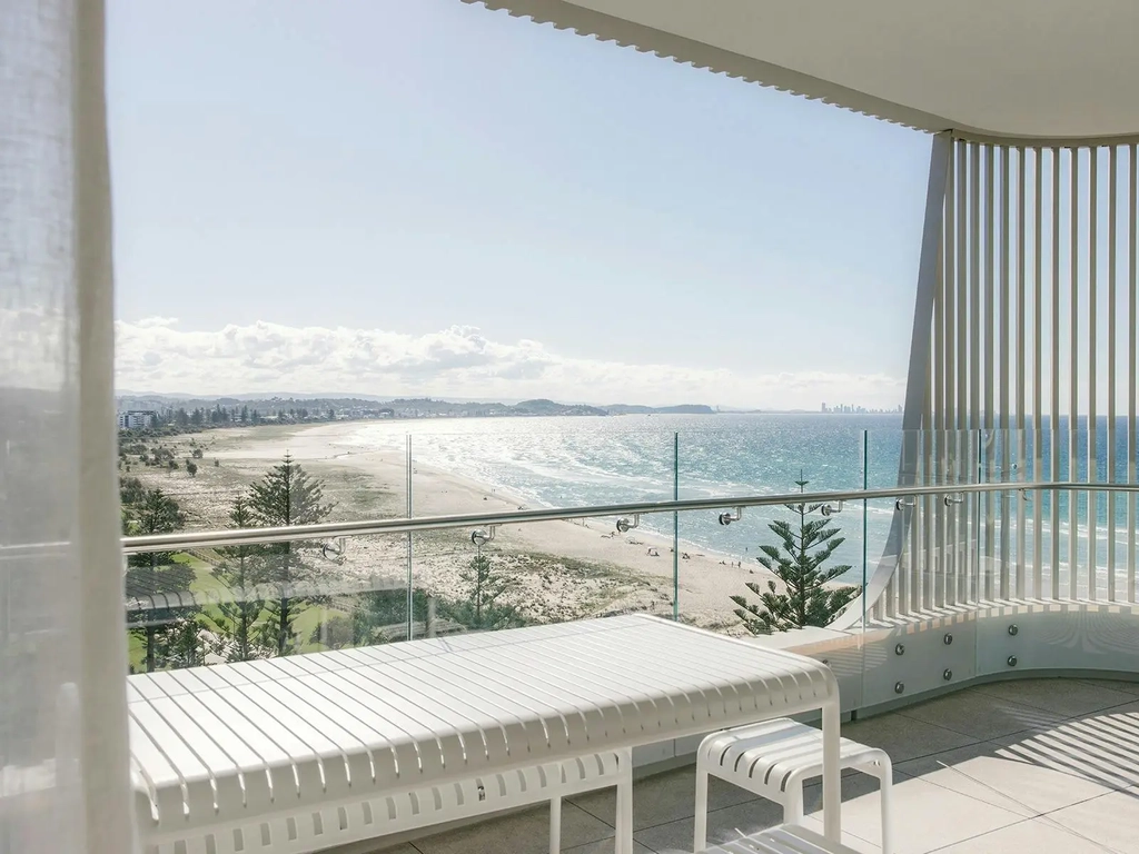 Kirra Point balcony with dining table and sweeping coastal views toward Surfers Paradise skyline