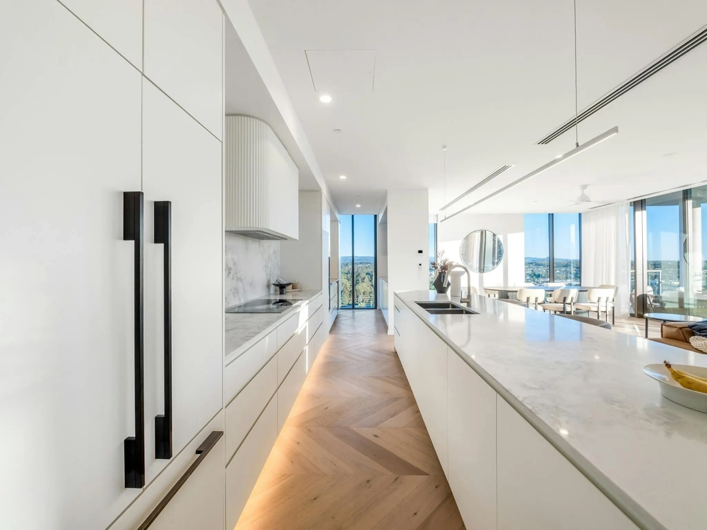 Galley kitchen with stone benchtops and herringbone oak flooring