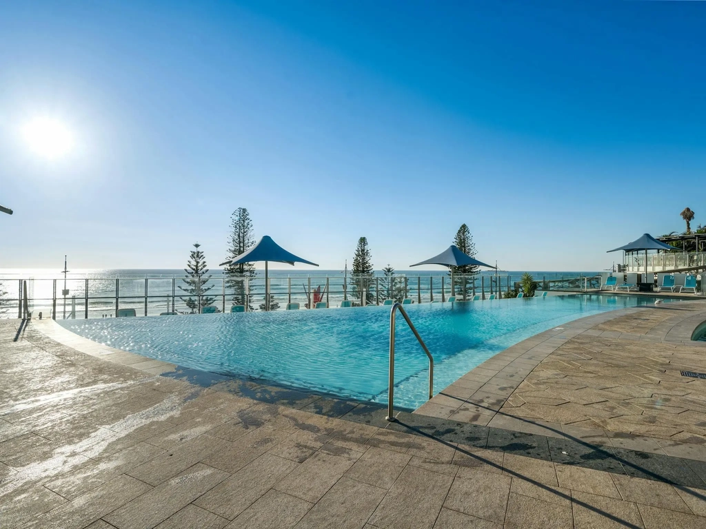 Outdoor swimming pool on a podium terrace above the beach.