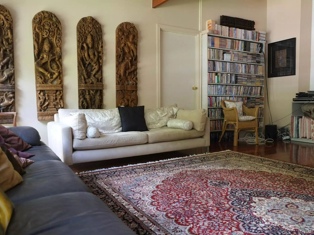 a common area room within Nirvana Wellbeing Retreat with sofas books and dvds