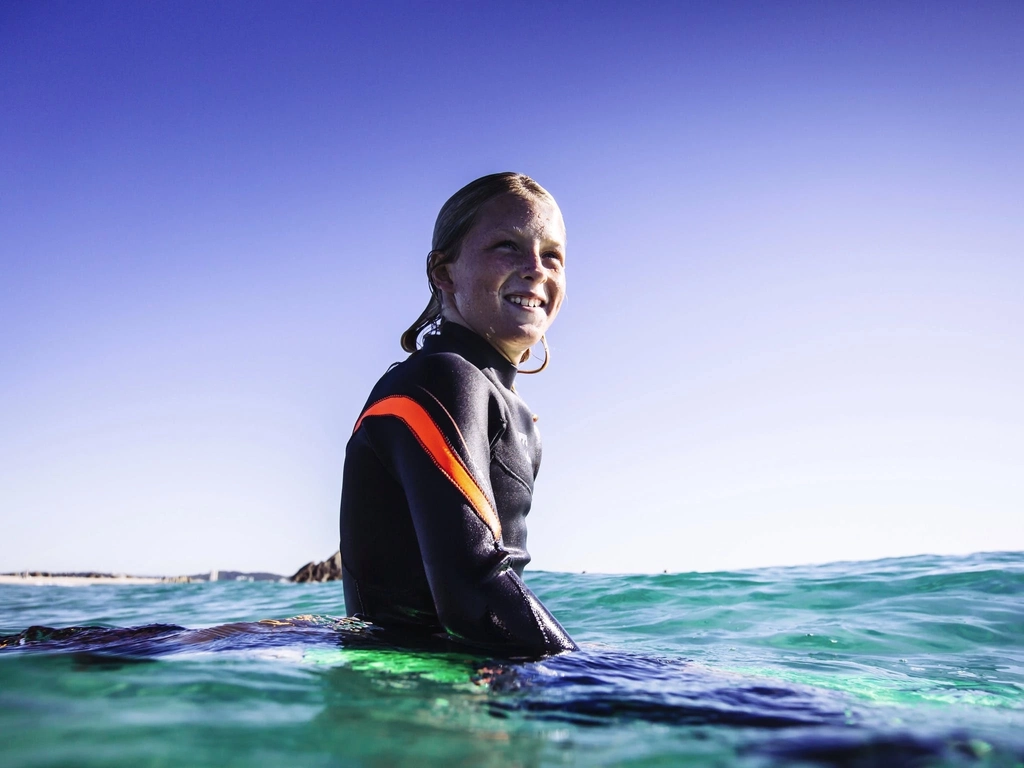 Child sitting on surf board