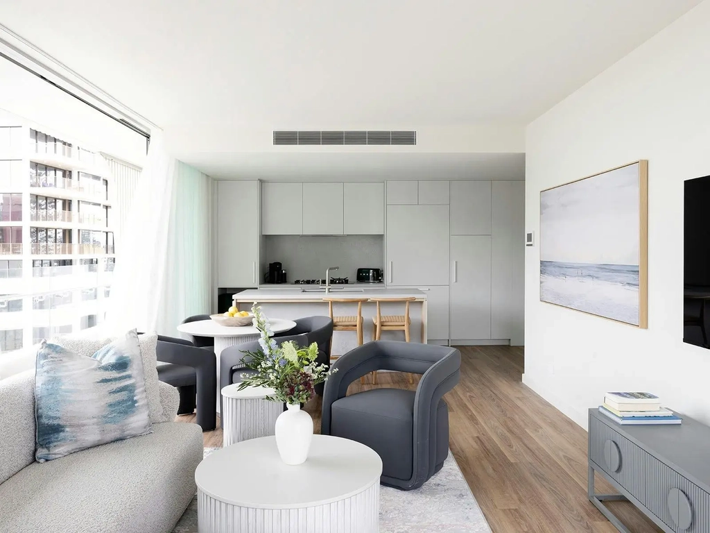 Open-plan living area at Kirra Point Holiday Apartments featuring coastal décor and full kitchen