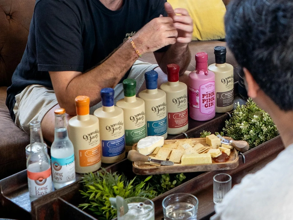 Gin tasting experience with Granddad Jack’s bottled spirits and cheese board on a shared table.