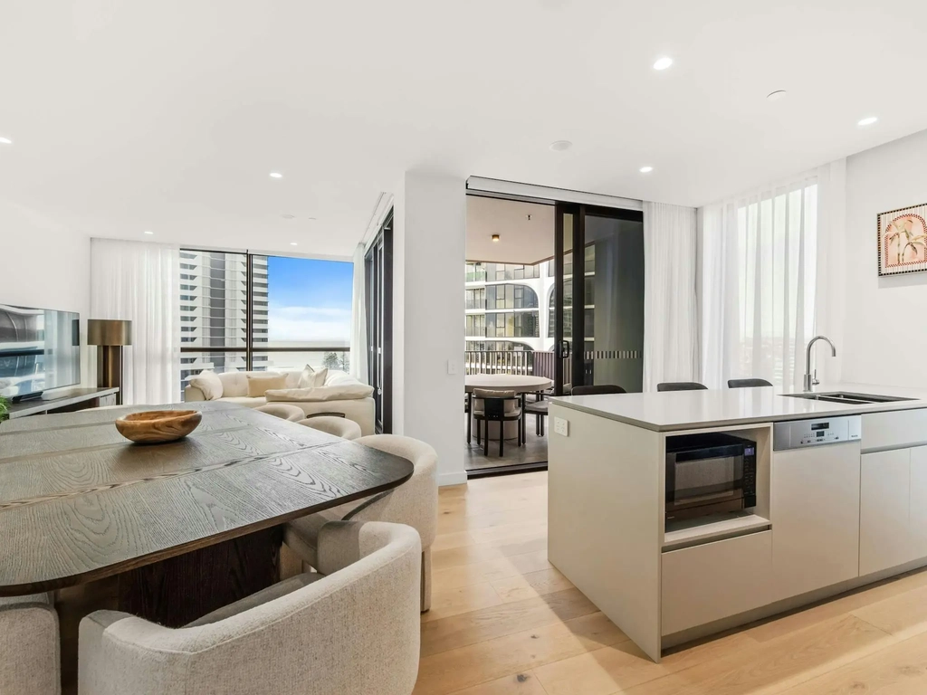 Open plan living, dining and kitchen with timber floors and an ocean outlook.