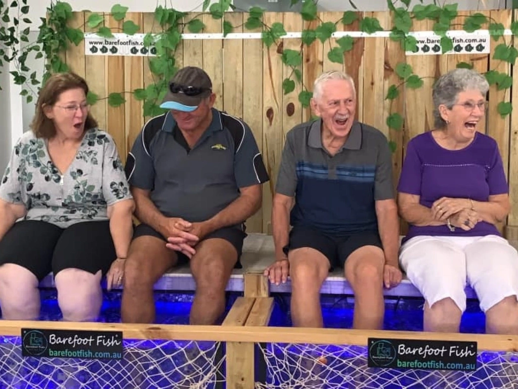 A group of 4 people enjoying a fish spa at Barefoot Fish