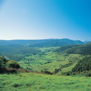 Scenic view overfarland and distance rainforested mountains.