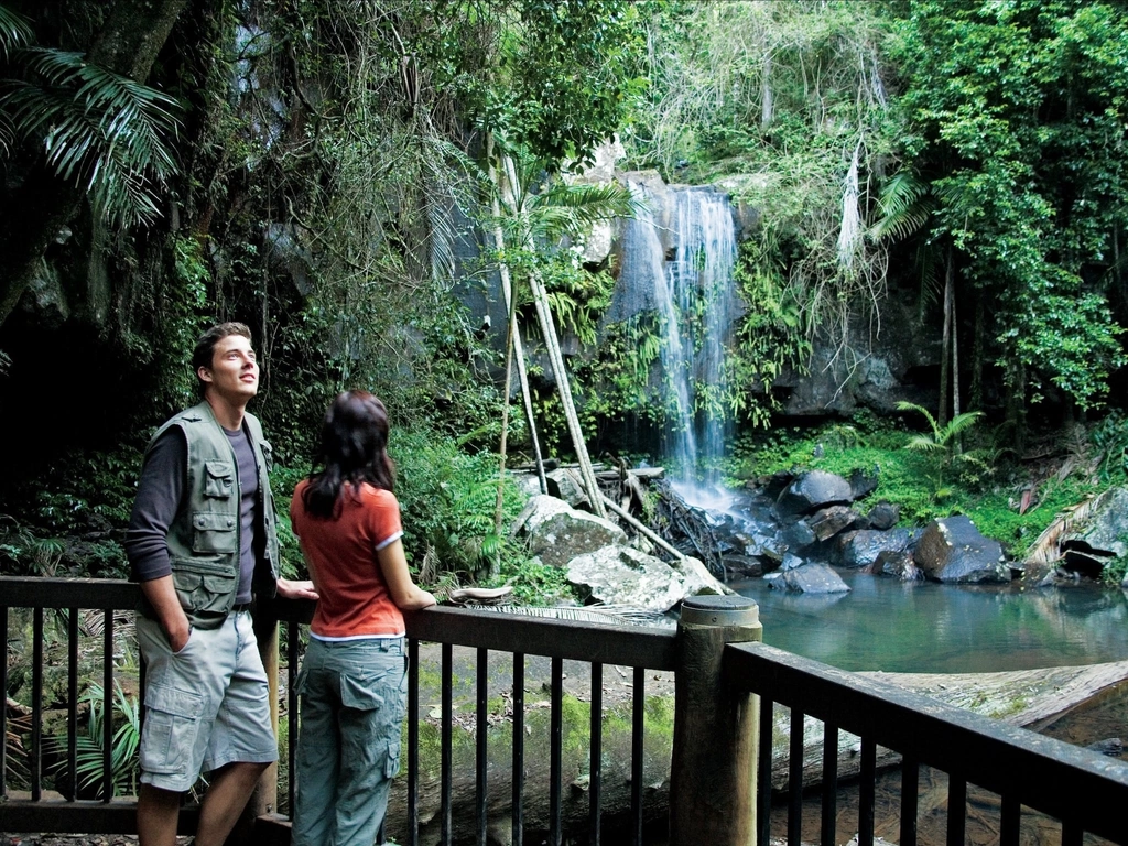 Couple standing on viewing deck with falls in background.
