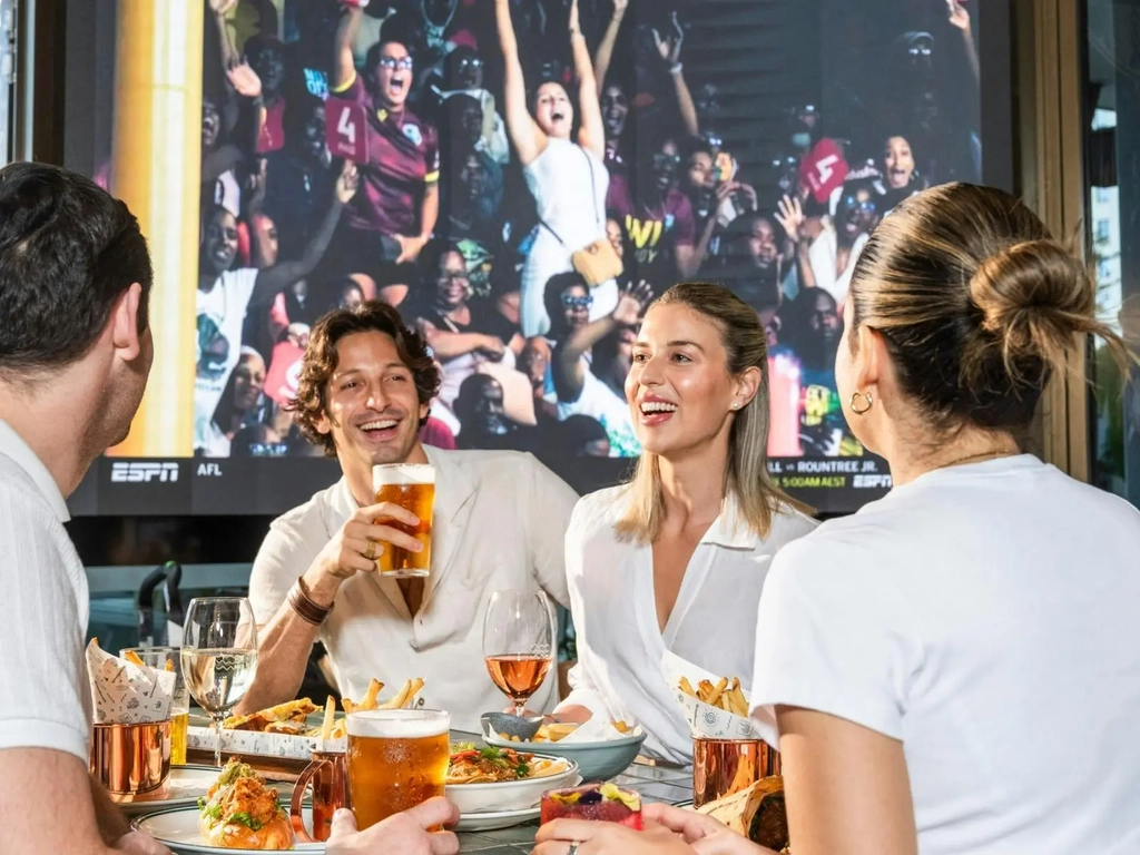 Customers enjoying food while watching sports