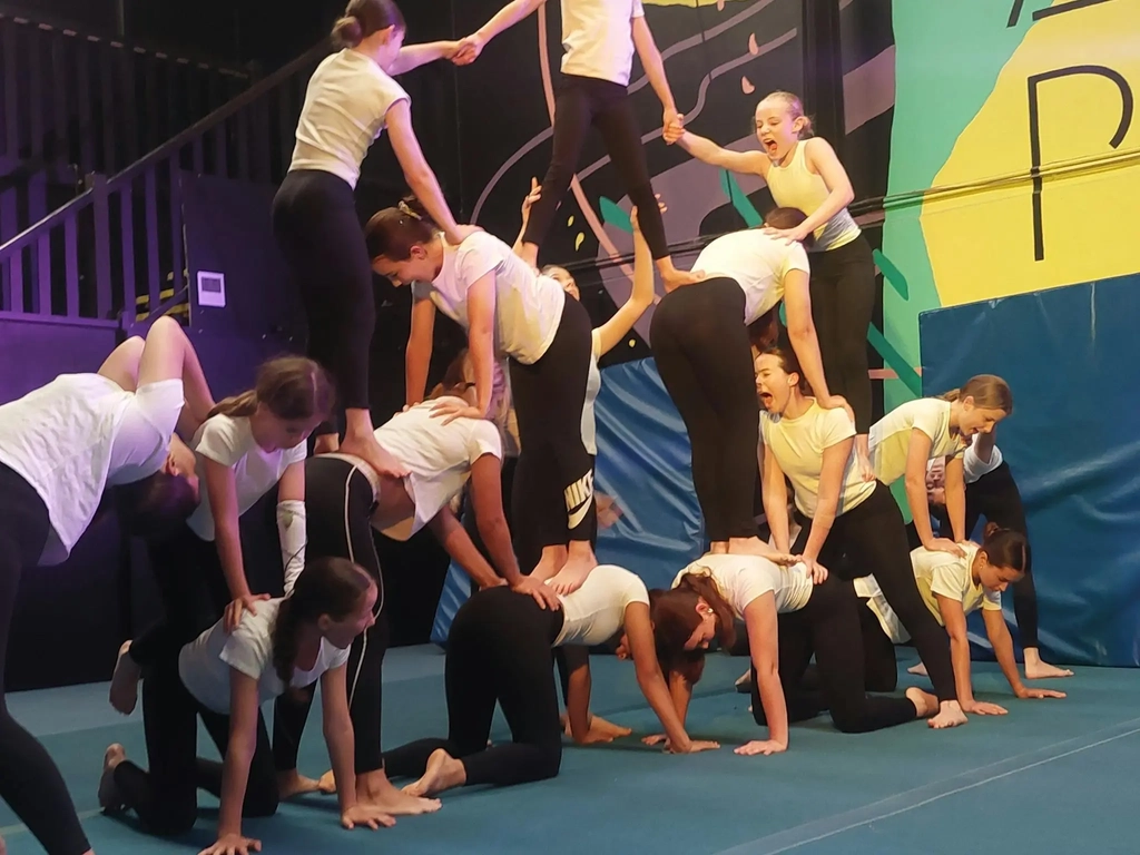 14 young people standing in a human pyramid