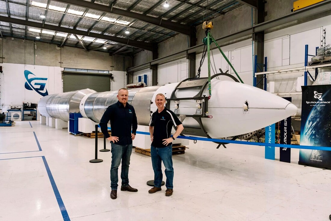 ADAM AND JAMES GILMOUR infront of large space rocket