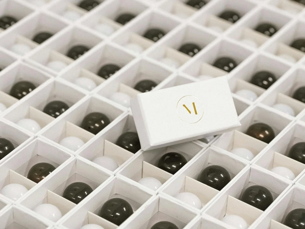 Rows of 2piece chocolate boxes sitting open with a branded lid featuring an ''M'' logo