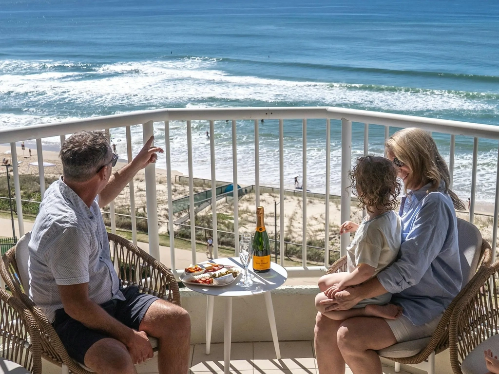 Family sitting on balcony overlooking the ocean