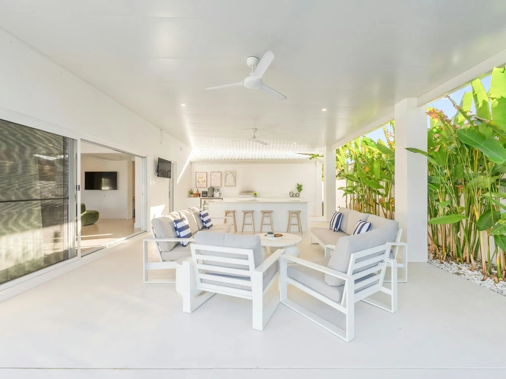Covered alfresco cabana with lounge seating and a barbecue