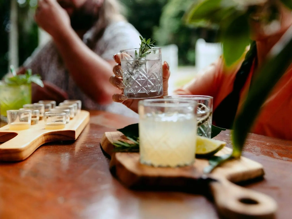Guests seated at a tasting bench enjoying a guided gin tasting at Tamborine Mountain Distillery, sam