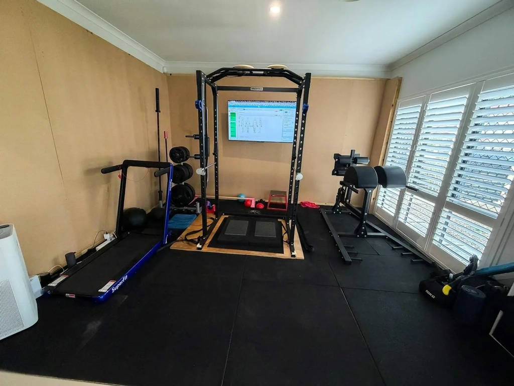 Heal Young Massage training room with strength rack and movement assessment equipment.