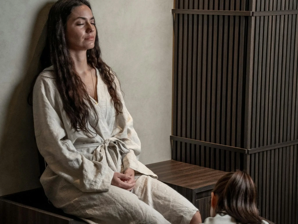 Yūsen therapist performs a foot ritual in a private, timber-panelled treatment room.
