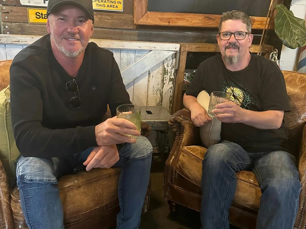 Two customers enjoying a drink on the couches.