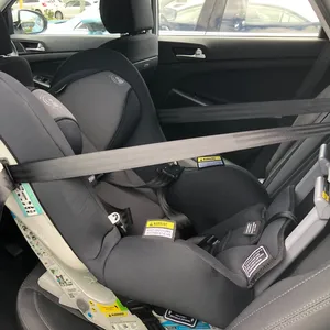 A greay rearward facing car seat installed into a car.