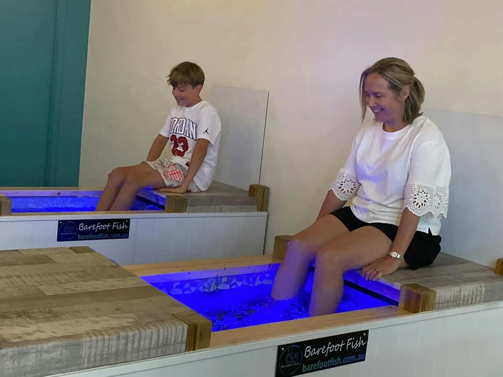 Two people enjoying a Fish Spa at Barefoot Fish