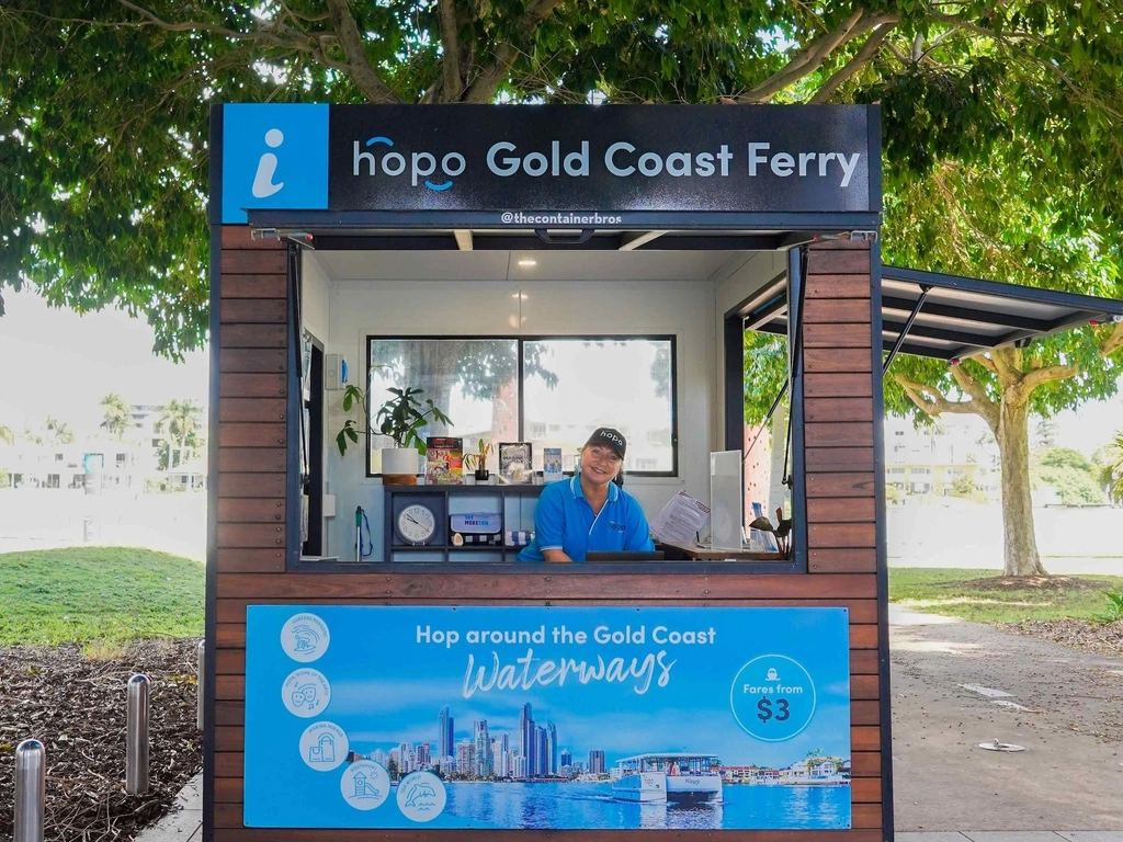 Woman in blue Hopo shirt stands inside Hopo Information Kiosk