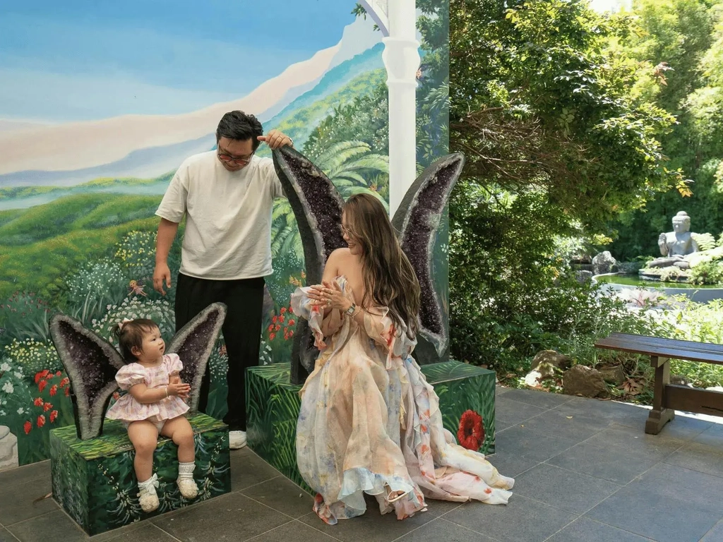 A happy family sitting in front of the amethyst wings at Crystal Castle