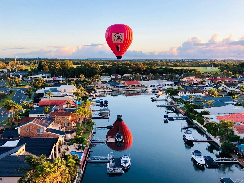 Coastal mirror shot, balloon floating  over houses and canals